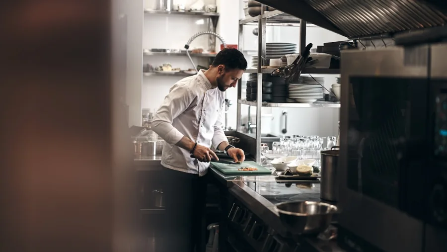 Chef preparing an order inside a professional restaurant kitchen
